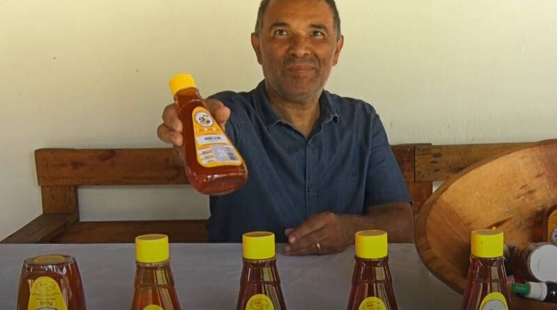 Homem segurando mel envasado
