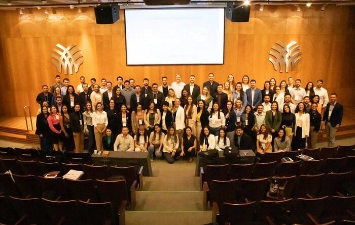 Pessoas em pé, em um palco, em evento da CNA