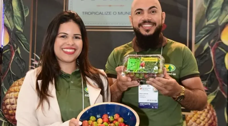 Mulher e homem sorrindo segurando potes com acerola
