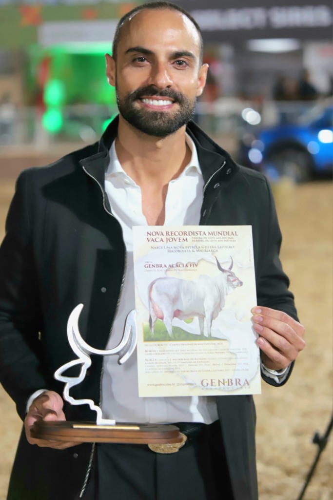 Eros Gazzinelli, da GenBra Agropecuária, segura troféu e certificado em homenagem à vaca Acácia FIV, nova recordista na categoria vaca jovem do Guzerá Leiteiro.