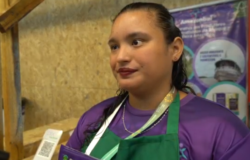 Uma mulher com blusa roxa e avental verde 