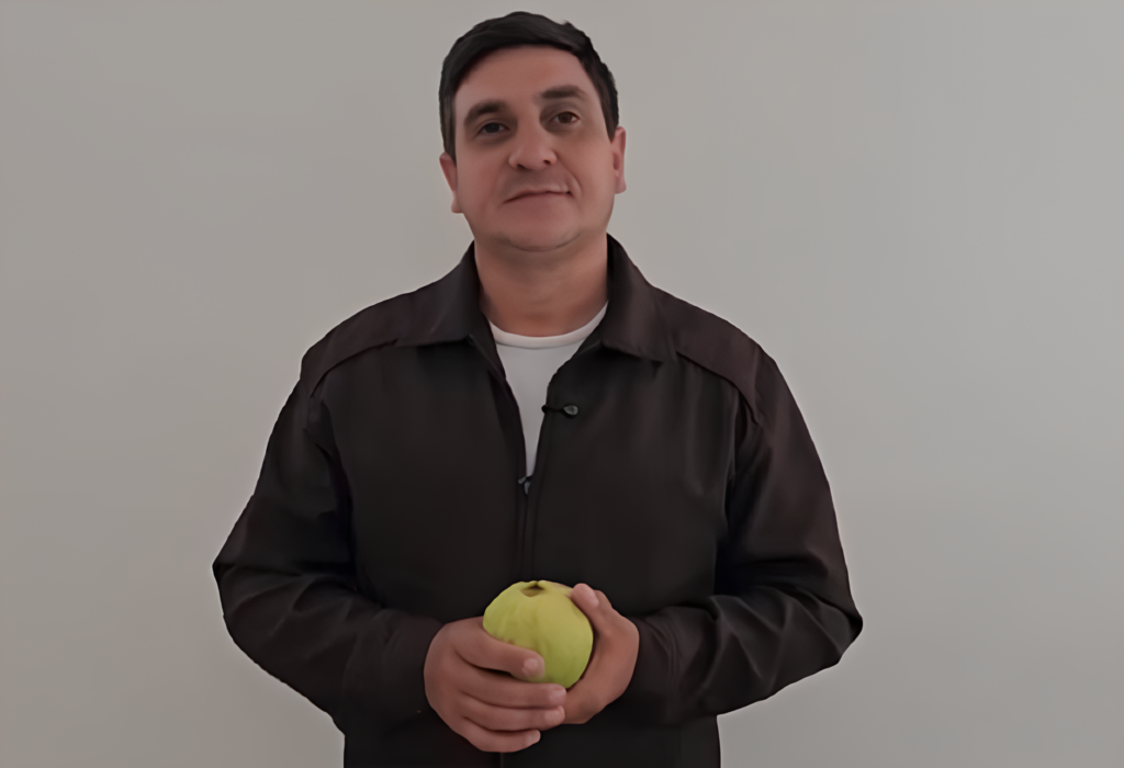 Agricultor segurando uma goiaba.