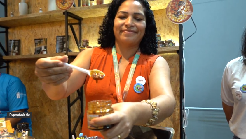 mulher com pote de mel nas mãos