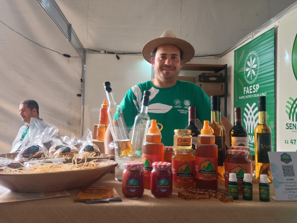 Na foto, está um homem mostrando a sua produção de méis. 